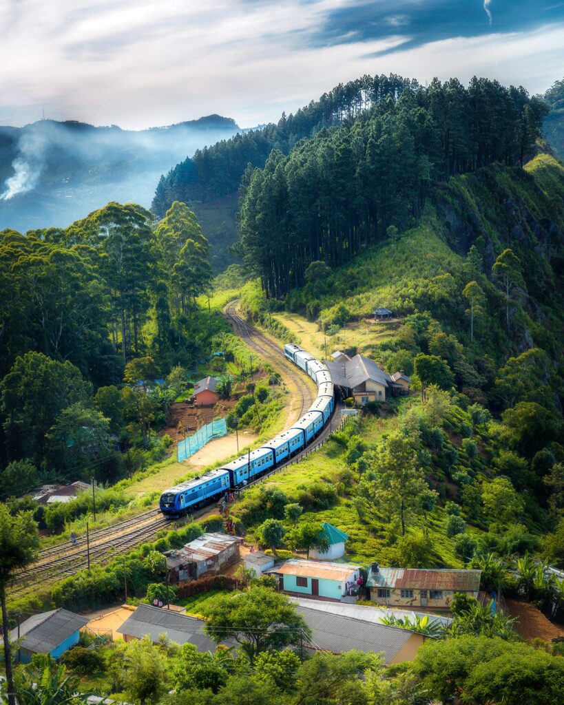 pexels-photo-1658967-1658967 Aerial view of a picturesque train winding through lush green hills and rural houses.