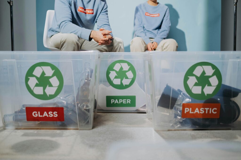 pexels-photo-6591427-6591427 Volunteers organize recyclables into glass, paper, and plastic bins to promote eco-friendly practices.