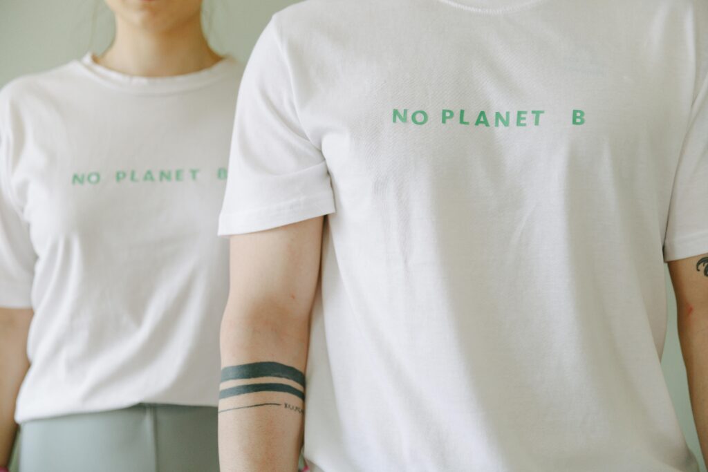 pexels-photo-7655830-7655830 Close-up of two people wearing white 'No Planet B' T-shirts, promoting environmental awareness.