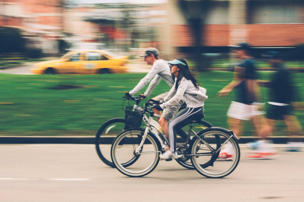 pexels-photo-386024-386024 Blurred image of a couple cycling in a city street, capturing speed and motion.